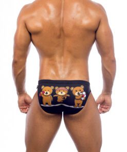 Men's swimwear, briefs style, worn by a man, rear view, pattern with a design of three brown teddy bears exercising with three fuchsia accessories. Black background.